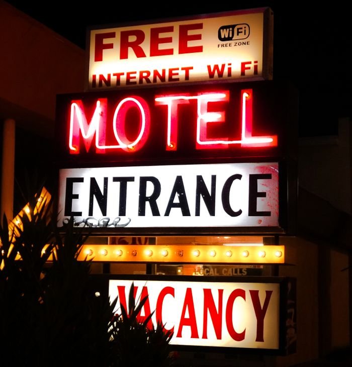 Illuminated neon motel sign advertising free Wi-Fi and vacancy at night.